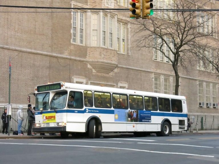 city bus carrying passengers along a busy street